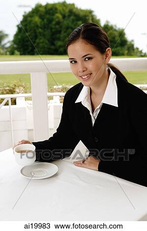 Businesswoman sitting in cafe, having coffee, looking at camera View Large Photo Image Stock Image - Businesswoman sitting in cafe, having coffee, looking at camera. Fotosearch