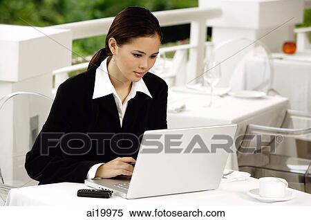 Businesswoman sitting in restaurant, using laptop View Large Photo Image Stock Photography - Businesswoman sitting in restaurant, using laptop. Fotosearch