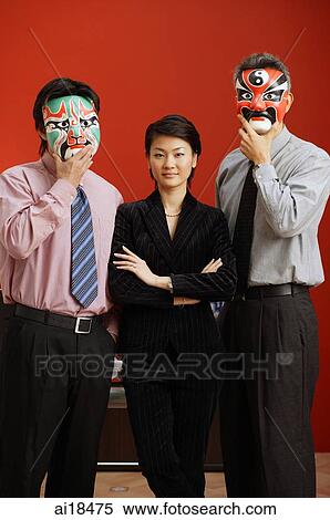 Businesswoman standing between two businessmen with Chinese masks over their faces View Large Photo Image Stock Photography - Businesswoman standing between two businessmen with Chinese masks over their faces. Fotosearch