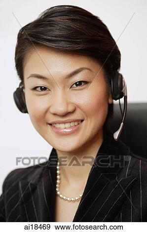 Businesswoman wearing hands free device, smiling at camera View Large Photo Image Stock Photo - Businesswoman wearing hands free device, smiling at camera. Fotosearch