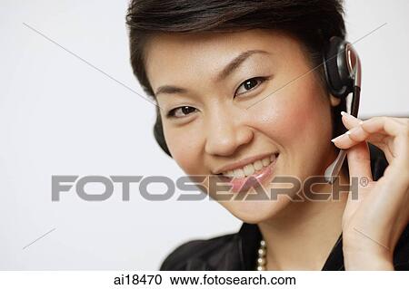 Businesswoman with hands free device, smiling at camera View Large Photo Image Stock Image - Businesswoman with hands free device, smiling at camera. Fotosearch