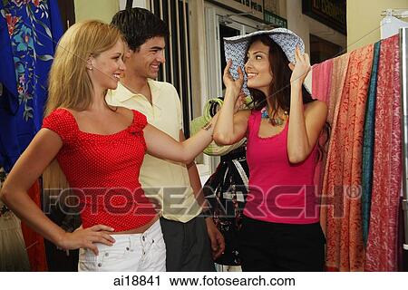 Caucasian tourists shopping, woman trying on hat View Large Photo Image Stock Image - Caucasian tourists shopping, woman trying on hat. Fotosearch