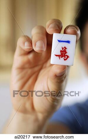 Close-up of hand holding mahjong tile with Chinese script View Large Photo Image Stock Photo - Close-up of hand holding mahjong tile with Chinese script. Fotosearch