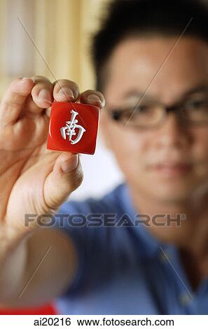 Close-up of hand holding red mahjong tile with Chinese script meaning South View Large Photo Image Stock Photograph - Close-up of hand holding red mahjong tile with Chinese script meaning South. Fotosearch