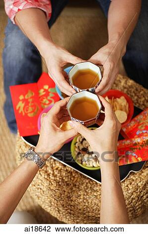 Close up of two pairs of hands, toasting with Chinese tea View Large Photo Image Stock Image - Close up of two pairs of hands, toasting with Chinese tea. Fotosearch