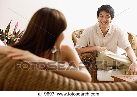 Couple at home in living room, woman turning to look at man View Large Photo Image Stock Photo - Couple at home in living room, woman turning to look at man. Fotosearch