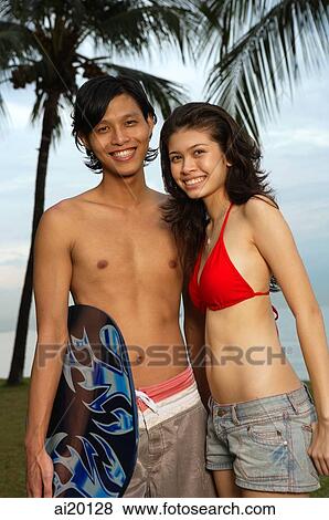 Stock Photo - Couple at the beach, looking at camera. Fotosearch