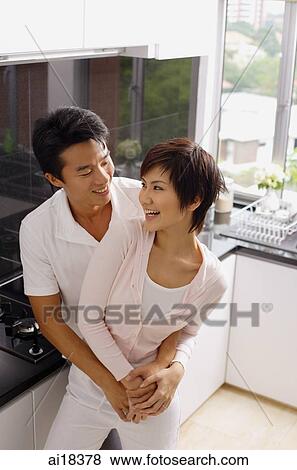 Couple embracing in kitchen View Large Photo Image Stock Photo - Couple embracing in kitchen. Fotosearch
