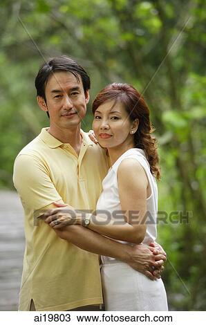 Couple embracing, looking at camera View Large Photo Image Stock Image - Couple embracing, looking at camera. Fotosearch