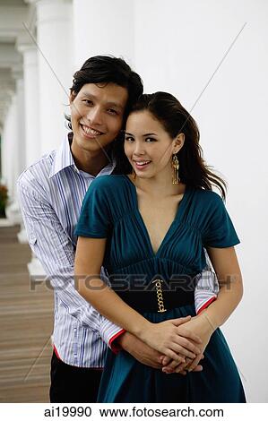 Couple embracing, looking at camera View Large Photo Image Stock Image - Couple embracing, looking at camera. Fotosearch