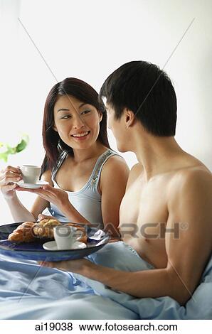 Couple having breakfast in bed View Large Photo Image Stock Photo - Couple having breakfast in bed. Fotosearch