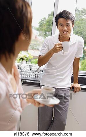 Couple having coffee in kitchen View Large Photo Image Stock Photograph - Couple having coffee in kitchen. Fotosearch