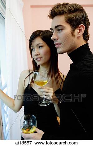 Couple holding wine glasses, looking away View Large Photo Image Stock Photo - Couple holding wine glasses, looking away. Fotosearch