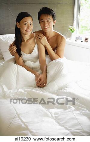 Couple in bed, looking at camera, portrait View Large Photo Image Stock Image - Couple in bed, looking at camera, portrait. Fotosearch