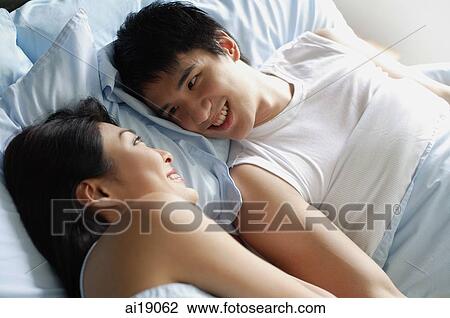 Couple in bed, looking at each other, smiling View Large Photo Image Stock Image - Couple in bed, looking at each other, smiling. Fotosearch
