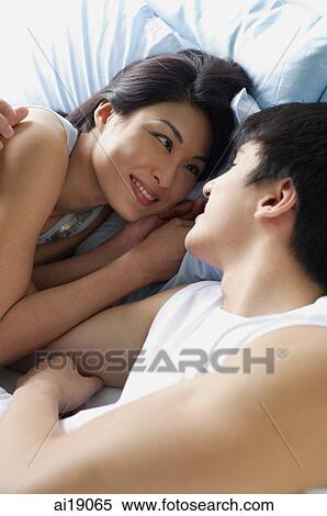 Couple in bed, smiling, face to face View Large Photo Image Stock Photography - Couple in bed, smiling, face to face. Fotosearch