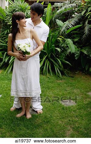 Couple in garden, looking at each other View Large Photo Image Stock Photo - Couple in garden, looking at each other. Fotosearch
