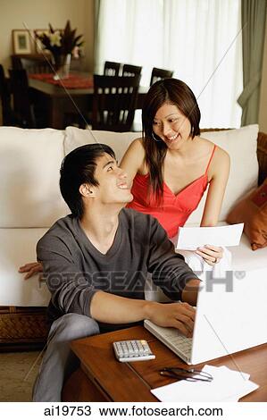 Couple in living room, paying bills View Large Photo Image Stock Image - Couple in living room, paying bills. Fotosearch