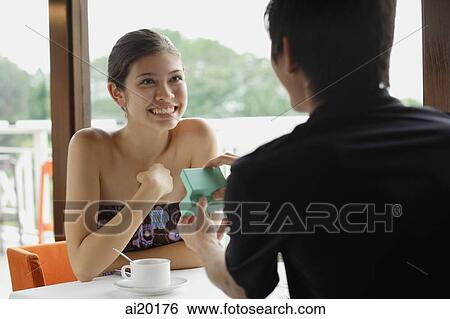 Couple in restaurant, man presenting woman with jewellery box View Large Photo Image Stock Photograph - Couple in restaurant, man presenting woman with jewellery box. Fotosearch