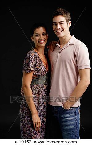 Couple in studio, standing side by side, smiling at camera View Large Photo Image Stock Image - Couple in studio, standing side by side, smiling at camera. Fotosearch
