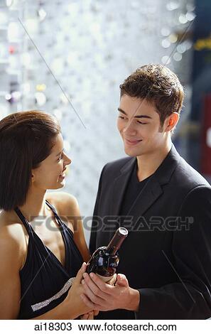 Couple in wine cellar looking at wine bottle View Large Photo Image Stock Image - Couple in wine cellar looking at wine bottle. Fotosearch