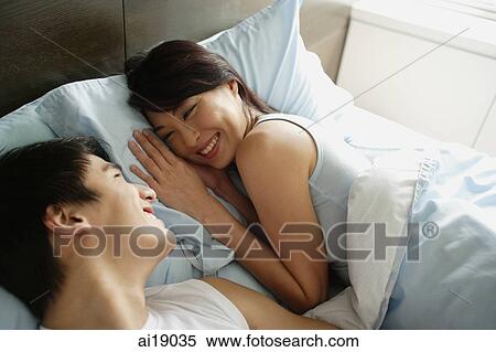 Couple lying in bed, smiling at each other View Large Photo Image Stock Photography - Couple lying in bed, smiling at each other. Fotosearch