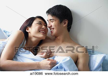 Couple lying side by side in bed, face to face View Large Photo Image Stock Photograph - Couple lying side by side in bed, face to face. Fotosearch