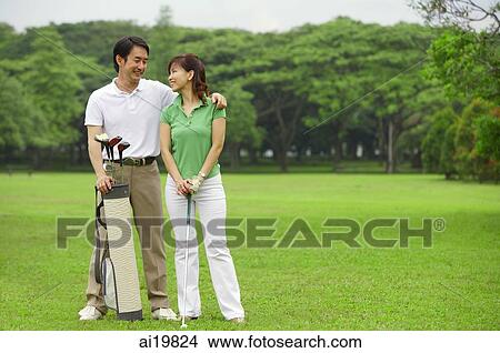 Couple on golf course, smiling at each other View Large Photo Image Picture - Couple on golf course, smiling at each other. Fotosearch