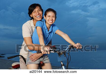 Couple on tandem bicycle, man embracing woman View Large Photo Image Picture - Couple on tandem bicycle, man embracing woman. Fotosearch