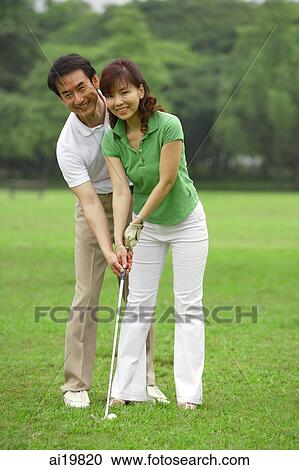 Couple playing golf, looking at camera View Large Photo Image Stock Image - Couple playing golf, looking at camera. Fotosearch