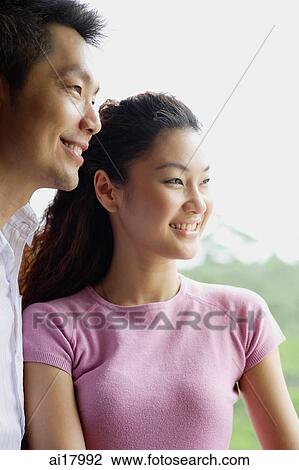Stock Image - Couple side by side, smiling and looking away. Fotosearch