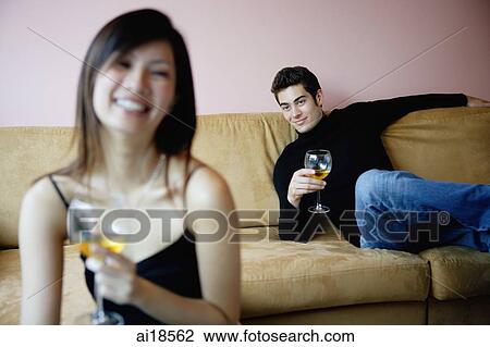 Couple sitting apart in living room, both looking at camera, focus on the man in the background View Large Photo Image Stock Image - Couple sitting apart in living room, both looking at camera, focus on the man in the background. Fotosearch