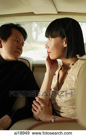 Couple sitting in car interior, facing each other, woman with hand on chin View Large Photo Image Stock Photo - Couple sitting in car interior, facing each other, woman with hand on chin. Fotosearch