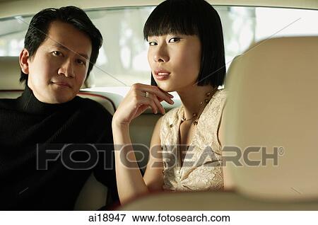 Stock Photo - Couple sitting in car interior, looking at camera. Fotosearch