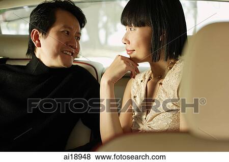 Couple sitting in car interior, looking at each other View Large Photo Image Stock Photo - Couple sitting in car interior, looking at each other. Fotosearch
