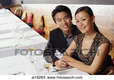 Couple sitting in restaurant, smiling at camera View Large Photo Image Stock Image - Couple sitting in restaurant, smiling at camera. Fotosearch