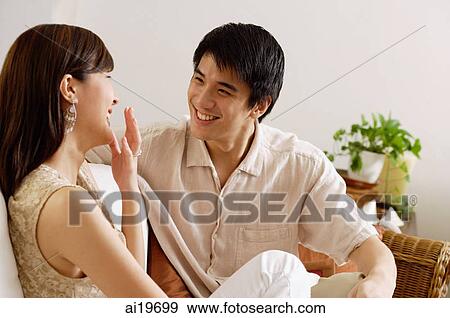 Couple sitting on sofa, smiling View Large Photo Image Stock Photo - Couple sitting on sofa, smiling. Fotosearch