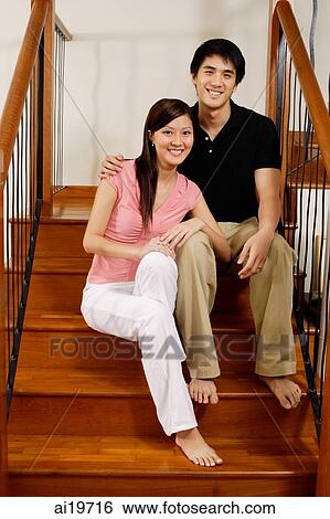 Couple sitting on stairs, looking at camera View Large Photo Image Stock Photograph - Couple sitting on stairs, looking at camera. Fotosearch