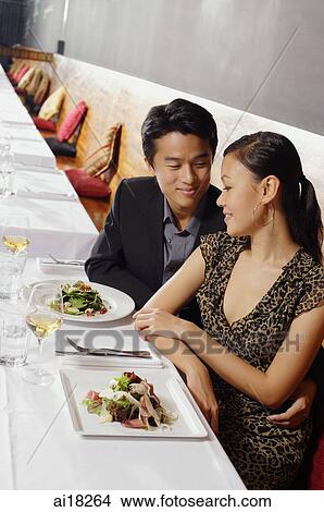 Couple sitting side by side in restaurant View Large Photo Image Picture - Couple sitting side by side in restaurant. Fotosearch