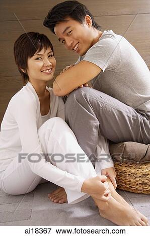 Couple sitting side by side, looking at camera View Large Photo Image Stock Photo - Couple sitting side by side, looking at camera. Fotosearch