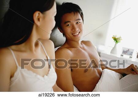 Stock Photograph - Couple sitting up in bed. Fotosearch