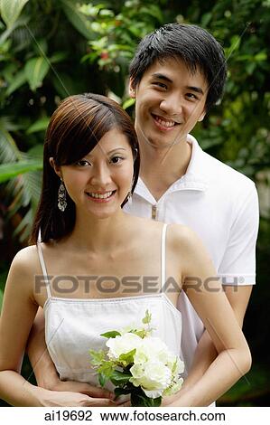 Couple standing in garden, smiling at camera View Large Photo Image Stock Image - Couple standing in garden, smiling at camera. Fotosearch