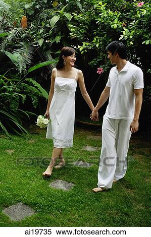 Couple walking in garden, holding hands View Large Photo Image Stock Photography - Couple walking in garden, holding hands. Fotosearch