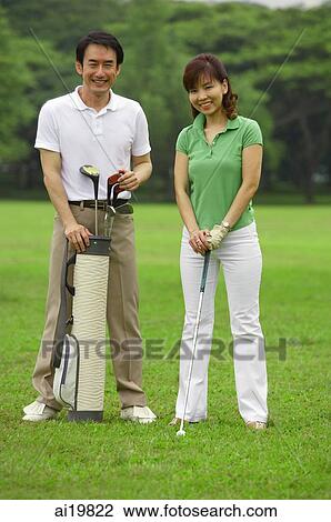 Couple with golf club and golf bag, smiling at camera View Large Photo Image Stock Image - Couple with golf club and golf bag, smiling at camera. Fotosearch