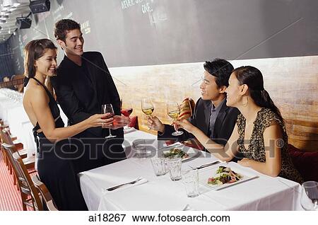 Couples in restaurant, toasting with wine glasses View Large Photo Image Stock Photo - Couples in restaurant, toasting with wine glasses. Fotosearch