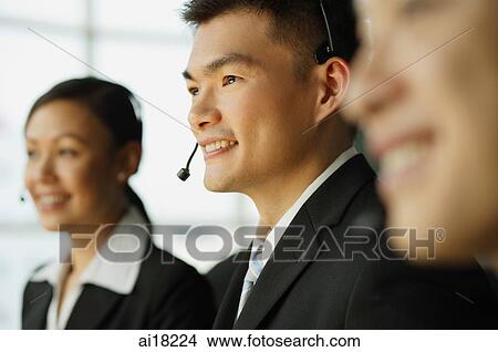 Picture - Customer service officers, in a row, focus on man in the middle. Fotosearch