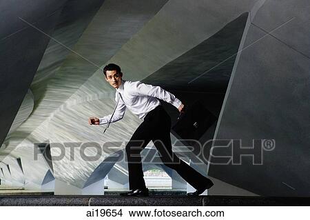 Executive in running pose, looking at camera View Large Photo Image Picture - Executive in running pose, looking at camera. Fotosearch