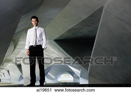 Executive with hand in pocket, standing, looking at camera View Large Photo Image Stock Image - Executive with hand in pocket, standing, looking at camera. Fotosearch