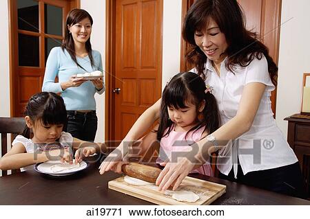 Family of females in kitchen, grandmother helping granddaughter to roll dough View Large Photo Image Stock Image - Family of females in kitchen, grandmother helping granddaughter to roll dough. Fotosearch