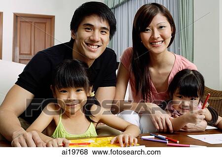 Family of four at home, looking at camera View Large Photo Image Stock Photo - Family of four at home, looking at camera. Fotosearch
